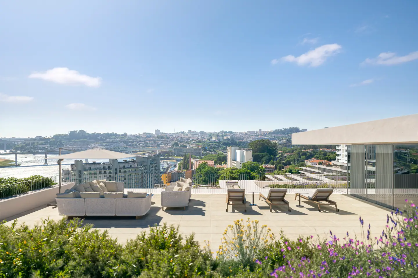 Rooftop terrace with sofas and loungers overlooking the river and Porto