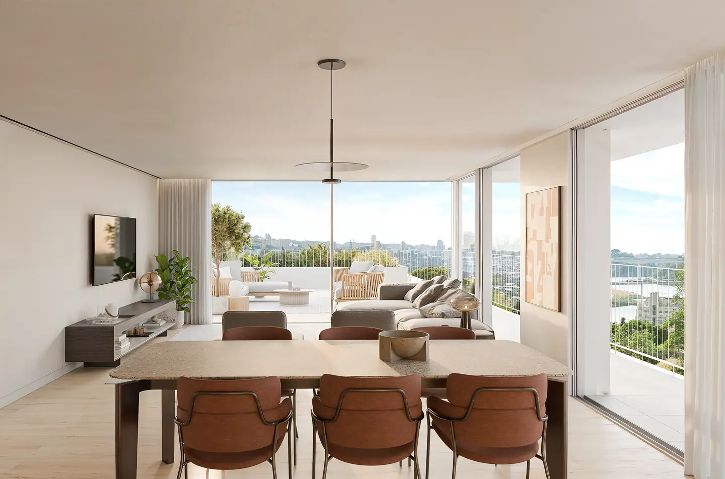 Dining table and living room open to a balcony with a river view